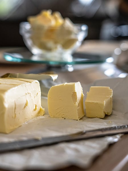 Beurre coupé en cubes sur son papier avec couteau