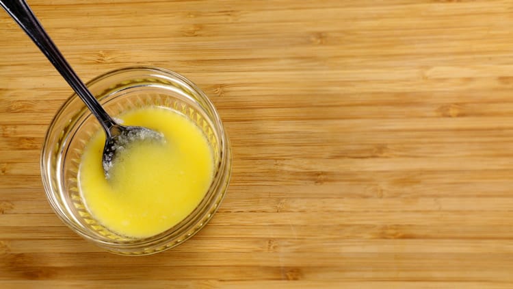 Petit bol de beurre sur planche de bois, résultat de l'article comment clarifier son beurre