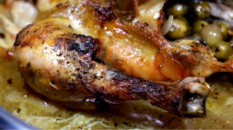Vue de près du poulet aux olives dans sa rôtissoire